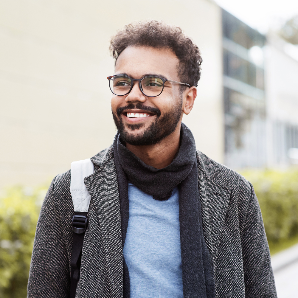 a man wearing glasses and smiling at the camera