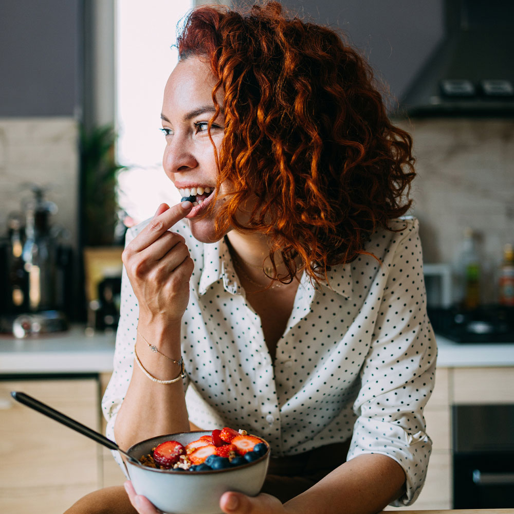 a woman sitting at a table eating food