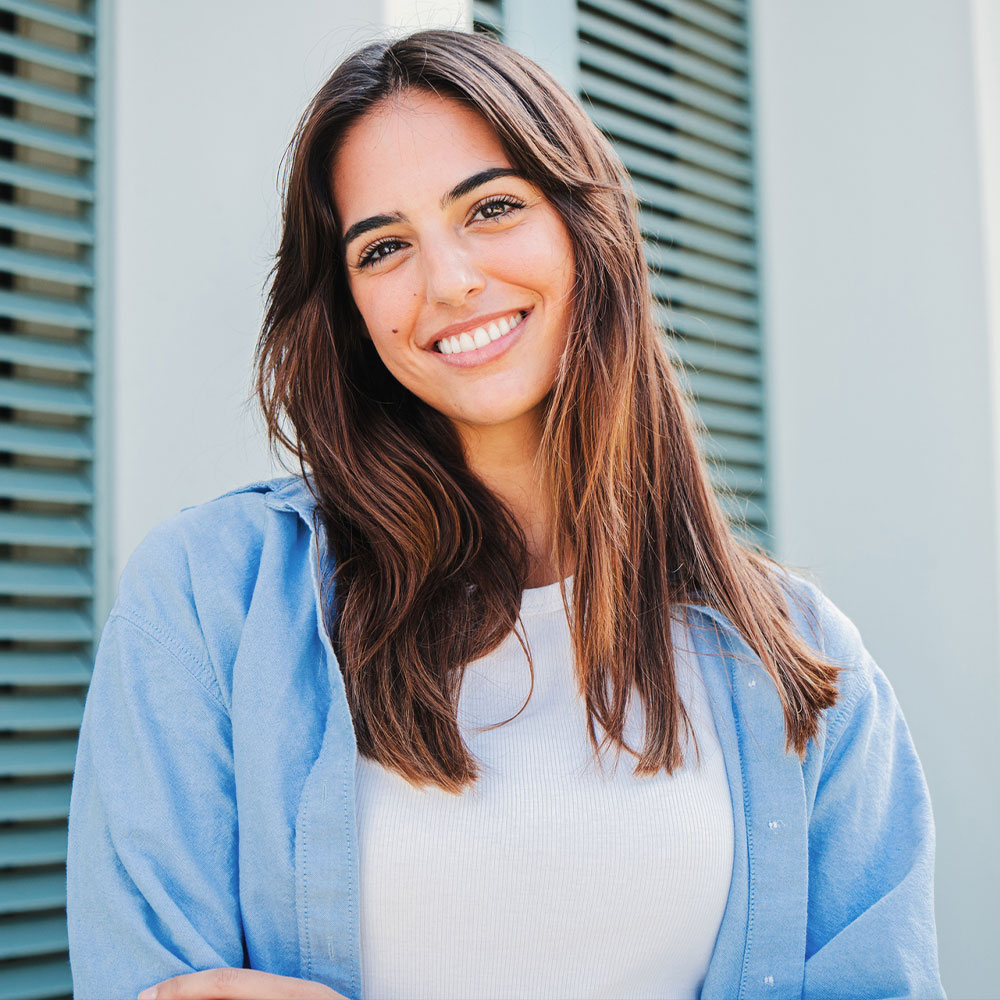 a woman in a blue shirt and smiling at the camera